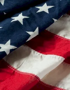 A close-up of the American flag, showing blue stars and red-and-white stripes.
